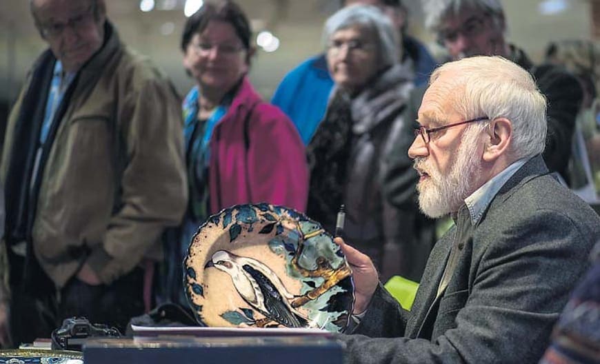 Curator Friggo Visser values a wall plate of the PZH painted by Jan van Schaick in department store Vanderveen in Assen. (Photography: DvhN, 23-11-2013)