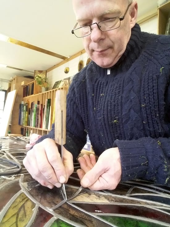 Glazenier Henry Duijvestijn bij de restauratie van de loodverbindingen, april 2016