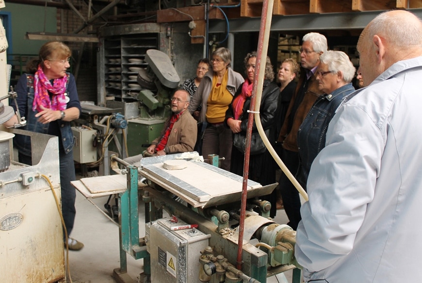 Rondleidster Yvon Kerkhoven demonstreert het werk aan de borden-persmachines.